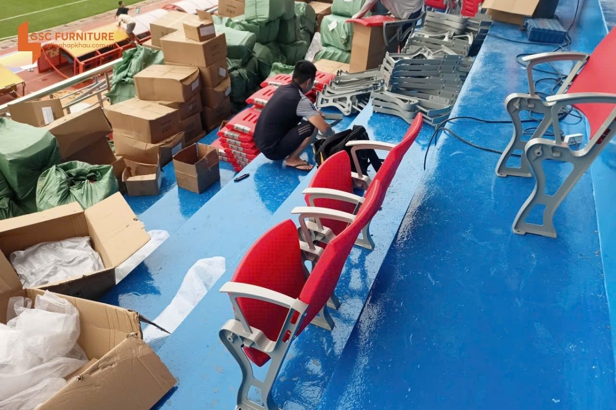 Các anh thợ đang lắp đặt ghế khán đài xuống sàn